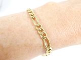 a gold chain bracelet on a woman ' s arm