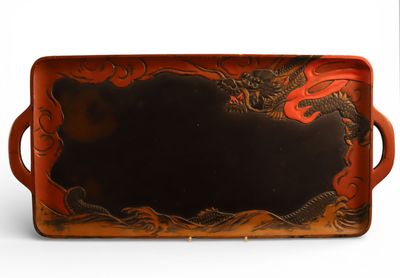 un plateau rouge orné d'un motif représentant un dragon