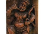 a wooden statue of a man with a guitar in his hand