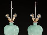 pair of green vases with gold accents on a red table
