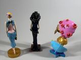 three figurines of a woman and a man with umbrellas
