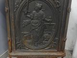 une vieille armoire en bois ornée d'une sculpture représentant une femme tenant un panier