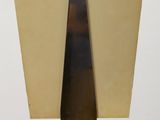 an art deco sculpture of a triangular shape on a glass base