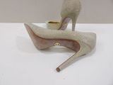pair of women ' s shoes on a white surface with a gold heel