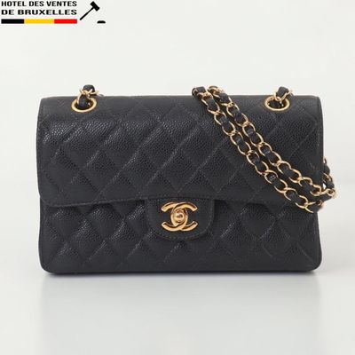 un sac Chanel noir avec des finitions dorées et une chaîne