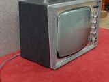 un petit téléviseur posé sur un tapis rouge