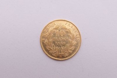 gros plan d'une pièce d'or sur une surface blanche