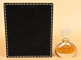 a close up of a bottle of perfume next to a black box