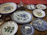 many plates and bowls on the table with a red table cloth