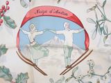 a picture of two people on skis on a table cloth