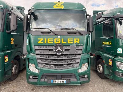 trois camions verts garés les uns à côté des autres sur un parking