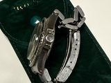 a watch sitting on a green case on a white table
