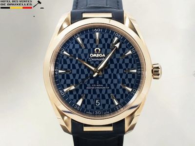 La montre est bleue et dorée, avec un motif en damier.