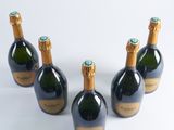 four bottles of champagne are lined up on a white surface