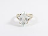 un gros plan d'une bague ornée d'une pierre transparente sur un fond blanc