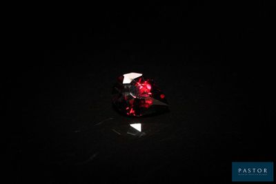 gros plan d'un diamant rouge sur une surface noire