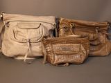 several purses are lined up on a gray surface