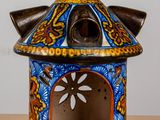 an image of a blue and yellow ceramic candle holder on a wooden table