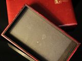 a red box that has a small glass in it