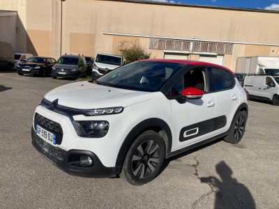 la petite voiture blanche est garée devant un bâtiment