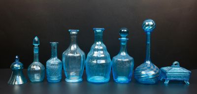 beaucoup de bouteilles en verre bleues posées sur une table