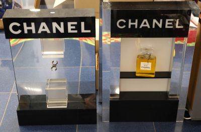 deux vitrines posées à même le sol, contenant des flacons de parfum