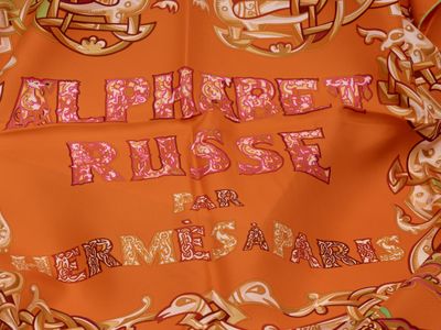 an orange scarf with a picture of a horse on it