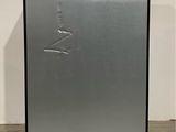 a close up of a metal refrigerator on a concrete floor