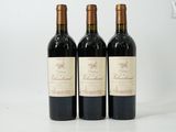 three bottles of wine sitting on top of a white table