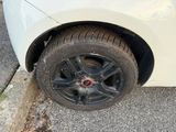 a white car with a black rim parked on the side of the road