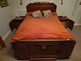 un lit avec une tête de lit en bois et un couvre-lit orange