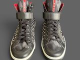 pair of black and red high top sneakers on a gray surface