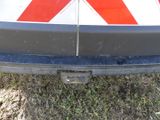 a close up of a red and white sign on the back of a car