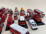 a lot of toy firetrucks and trucks on the table