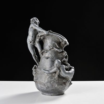 un vase en argent surmonté d'une statuette