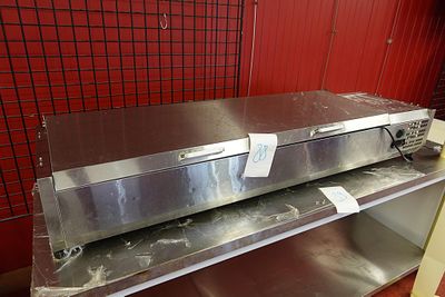 une étagère métallique sur laquelle est posé un four, dans une cuisine