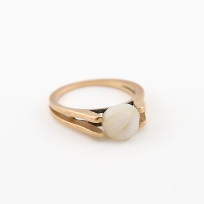 un gros plan d'une bague en or sertie d'une pierre blanche