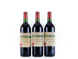 three bottles of red wine sitting next to each other on a white surface