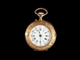 une montre de poche en or avec des chiffres romains