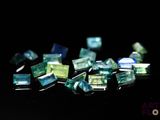 some green and blue glass pieces on a black surface