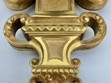 a gold clock that is on a white table