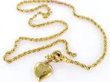 un gros plan sur un collier en or orné d'un cœur
