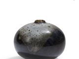 a black and white vase sitting on a white surface