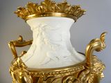 un vase en or surmonté d'un vase blanc