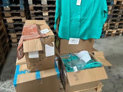 deux cartons de vêtements posés sur une palette dans un entrepôt