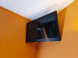 un téléviseur à écran plat fixé au mur dans un coin de la pièce