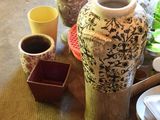 a table with plates, cups, and a vase on it
