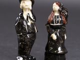 deux figurines d'un homme et d'une femme debout l'un à côté de l'autre
