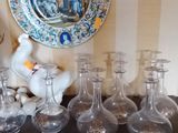 de nombreux vases en verre et une assiette posés sur une table