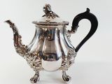 a silver teapot with a black handle on a white background